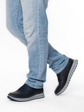 Load image into Gallery viewer, Person wearing blue jeans and black shoes on a white background
