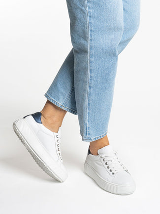 White sneaker with a black heel on a white background