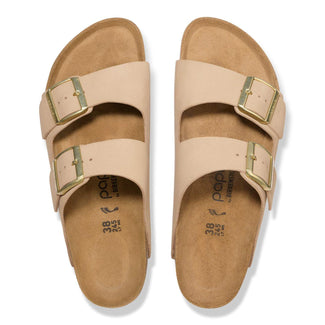 Beige sandal with gold buckles on a white background