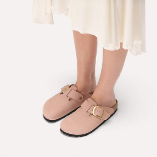 Pink clog sandal with gold buckle on a white background