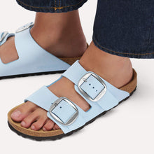 Load image into Gallery viewer, Light blue sandals with metallic buckles worn by a person on a white background
