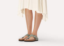 Load image into Gallery viewer, Person wearing gray sandals with a white background

