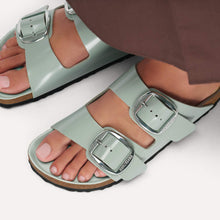 Load image into Gallery viewer, Light green sandals with silver buckles worn by a person on a white background

