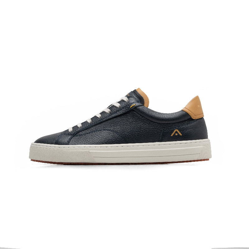 Navy blue sneaker with tan accents on a white background