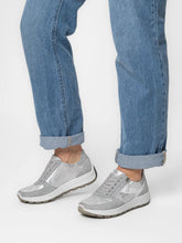 Load image into Gallery viewer, Gray sneakers worn with rolled-up blue jeans on a white background

