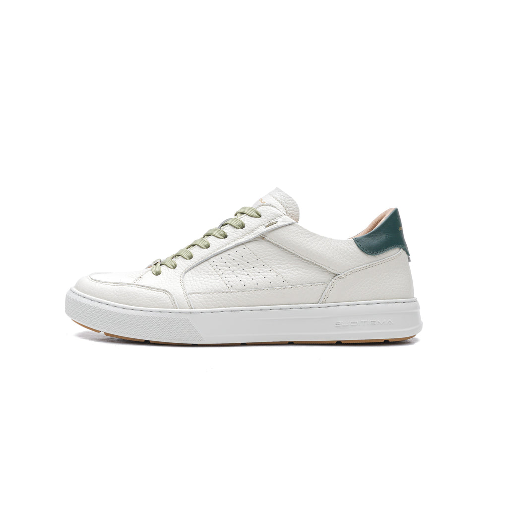 White sneaker with green accents on a white background