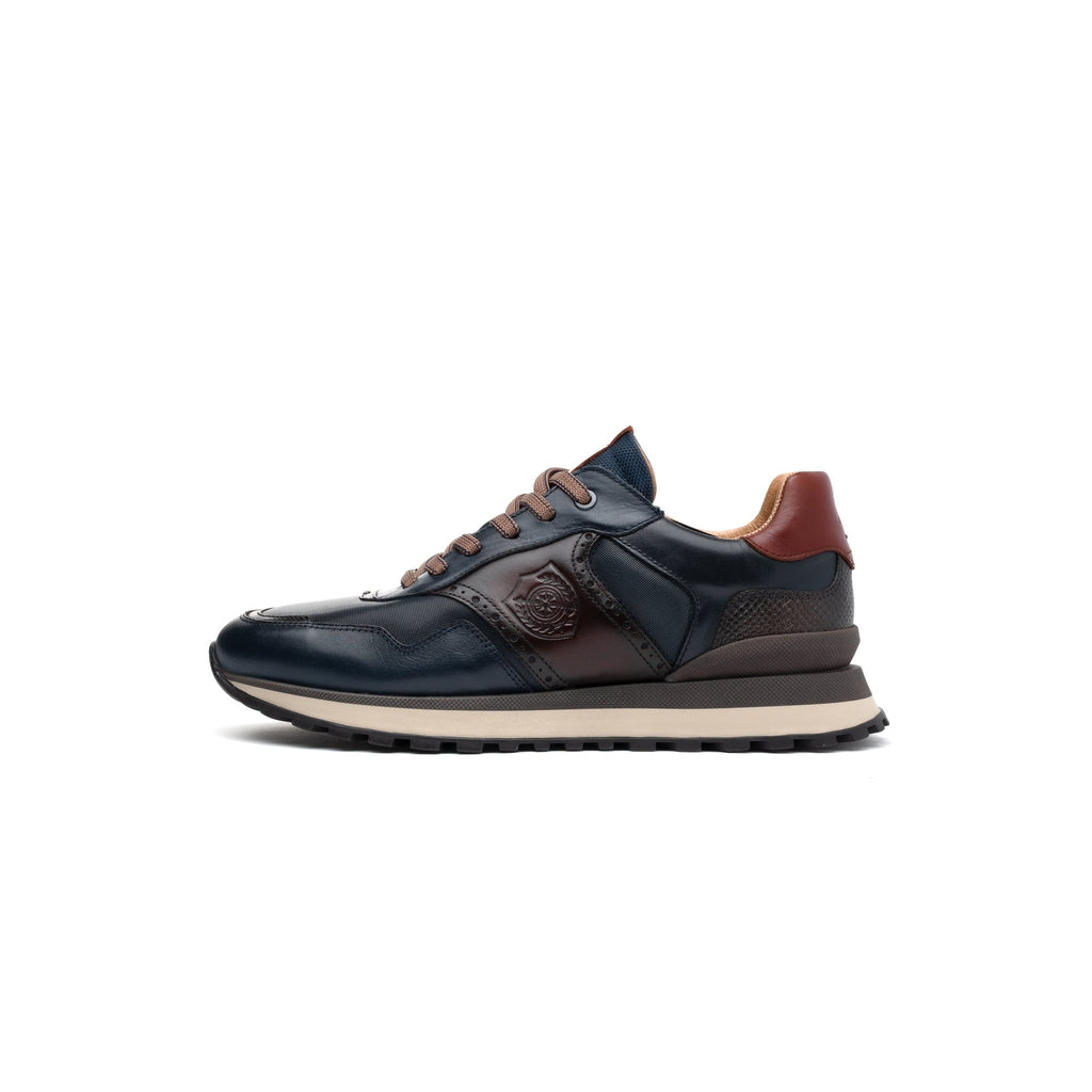 A single dark navy leather sneaker with brown accents, featuring a textured side panel, a debossed logo on the side, and a thick beige midsole, shown in profile against a white background.