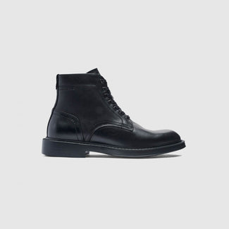 A pair of black leather lace-up ankle boots with a low block heel, shown from a side profile on a light gray background.