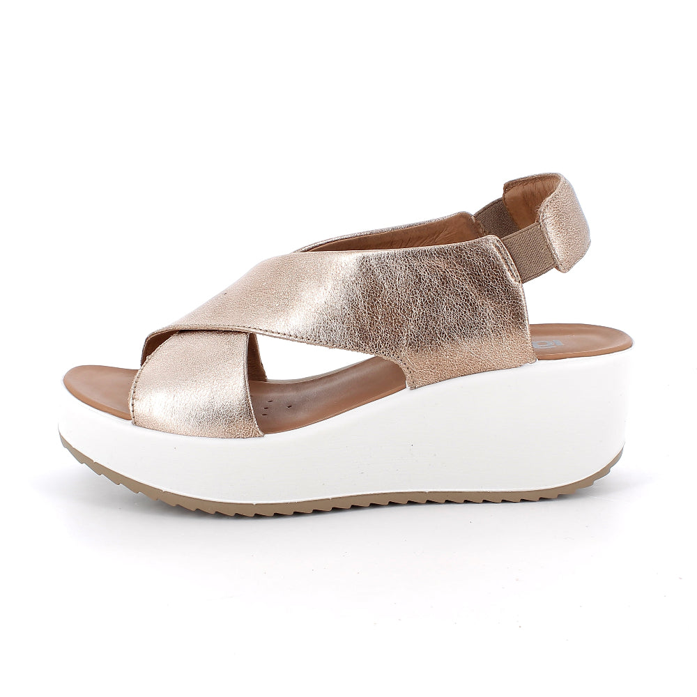 Gold wedge sandal on a white background