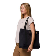 Load image into Gallery viewer, Woman carrying a black tote bag on a white background
