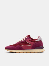 Load image into Gallery viewer, A low-top sneaker in shades of burgundy and magenta suede, featuring cream laces and a beige midsole, shown from a side profile on a light gray background.
