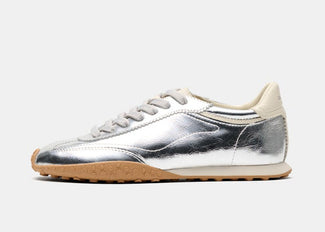 A metallic silver low-top sneaker with a beige heel tab, beige laces, and a tan rubber outsole, shown in a side profile on a light gray background.