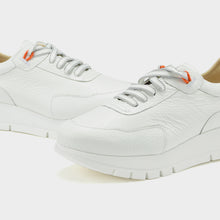 Load image into Gallery viewer, White sneakers with orange accents on a light gray background
