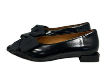Load image into Gallery viewer, A pair of black leather low-heel flats with bow details on the toe, shown from a side profile against a plain light gray background.
