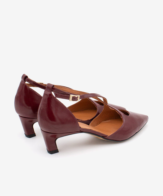 Brown high-heeled shoes with strappy design on a white background