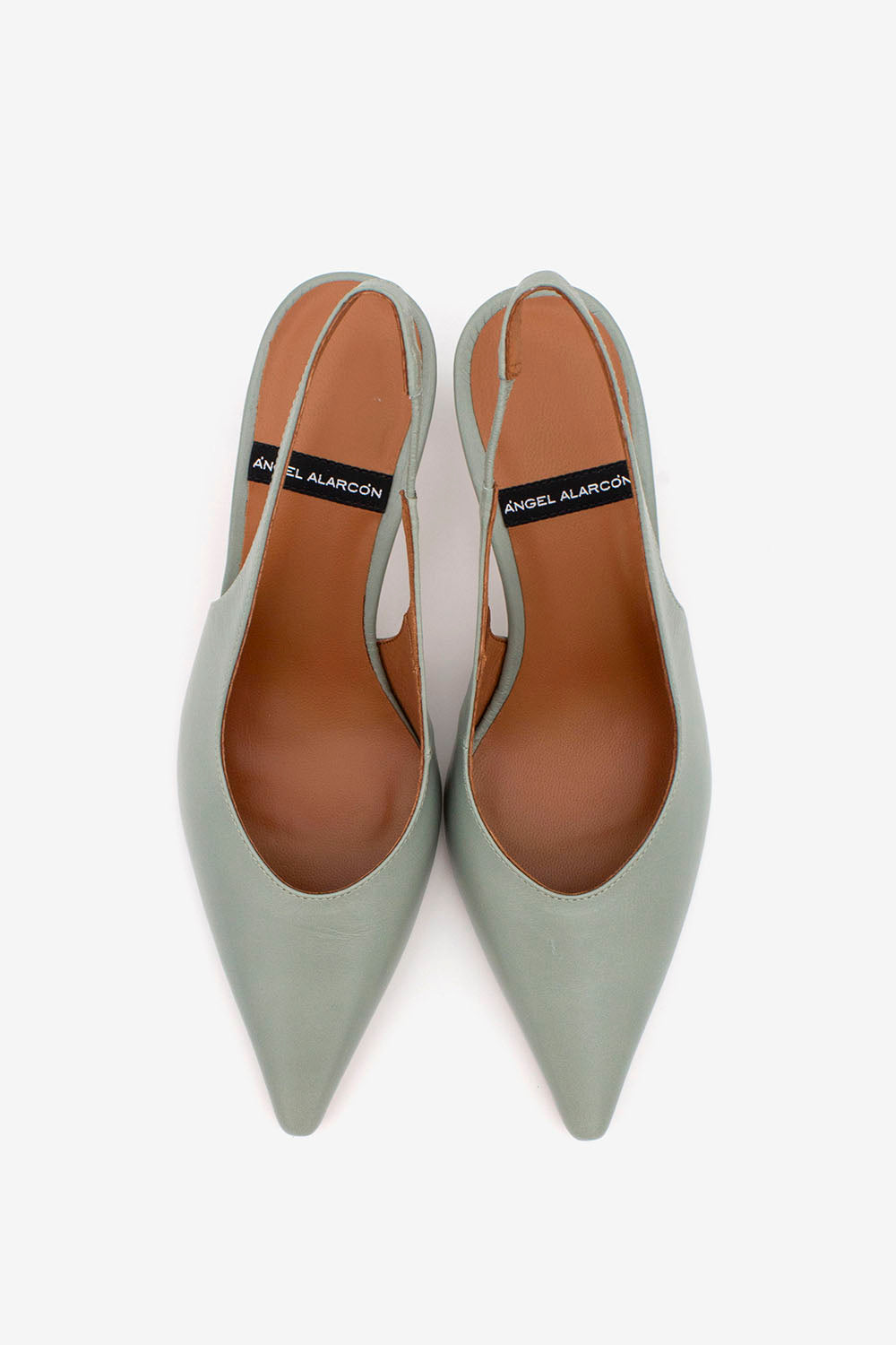 Pair of light gray high-heeled shoes with brown soles on a white background