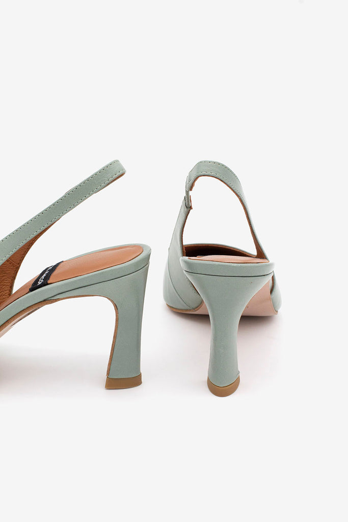 Pair of light green high-heeled shoes on a white background