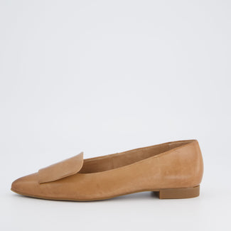 Tan leather flat shoe on a white background