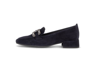 Navy blue loafer with a decorative buckle on a white background