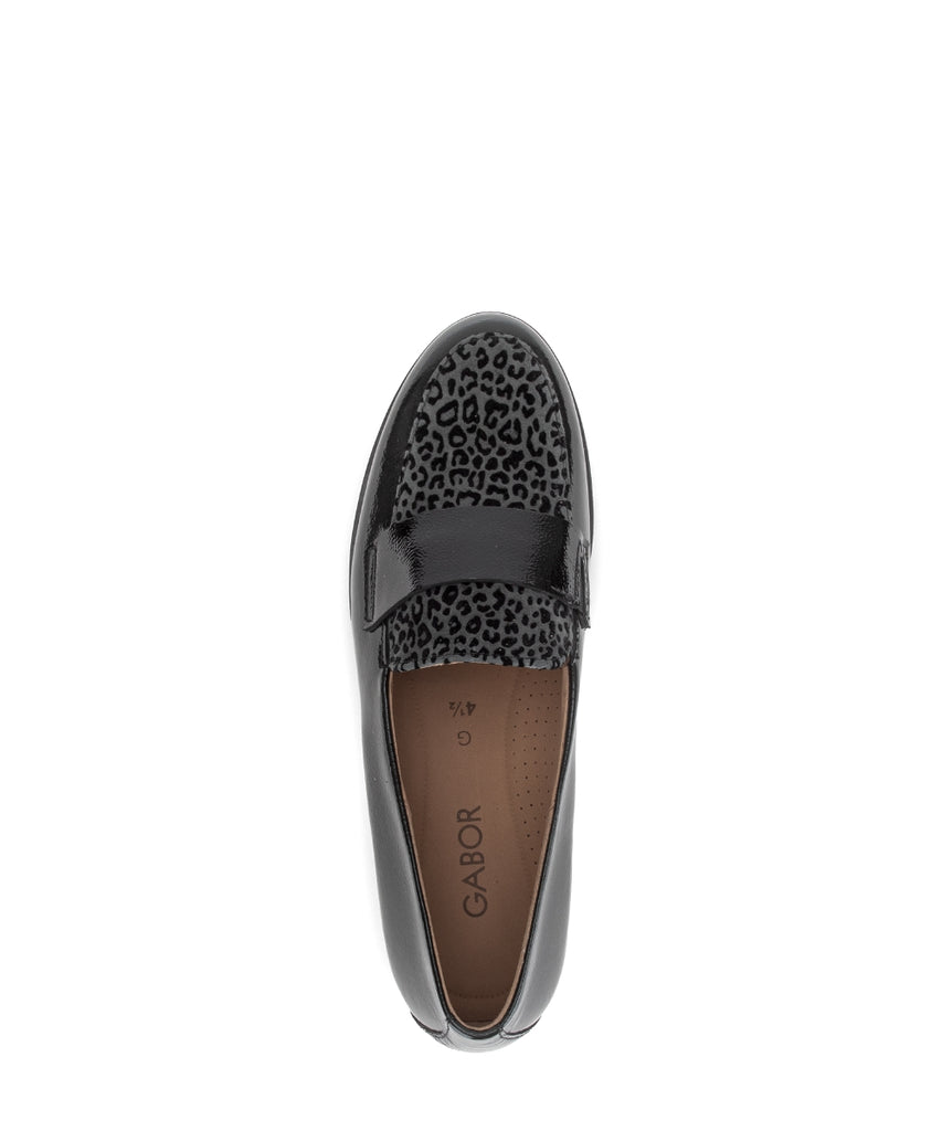 Black loafer with leopard print cap toe on a white background