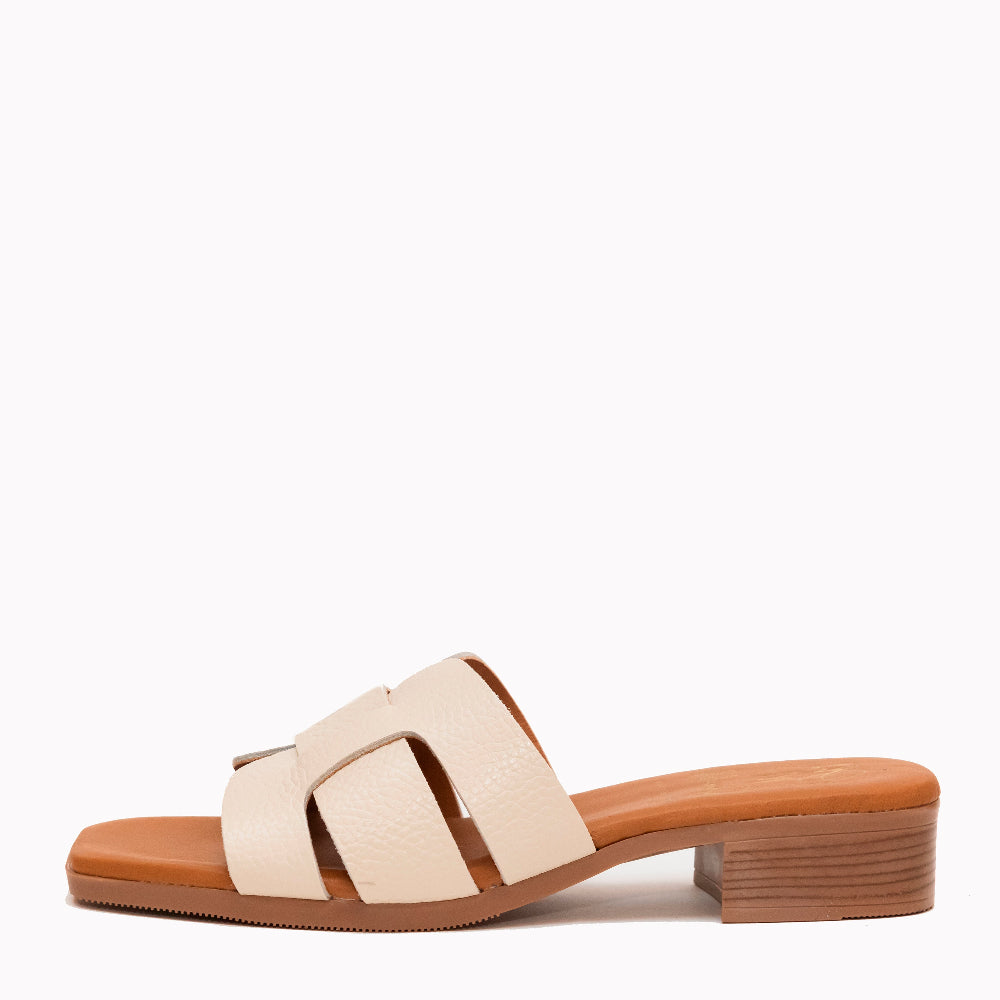 Beige sandal with a brown sole on a white background