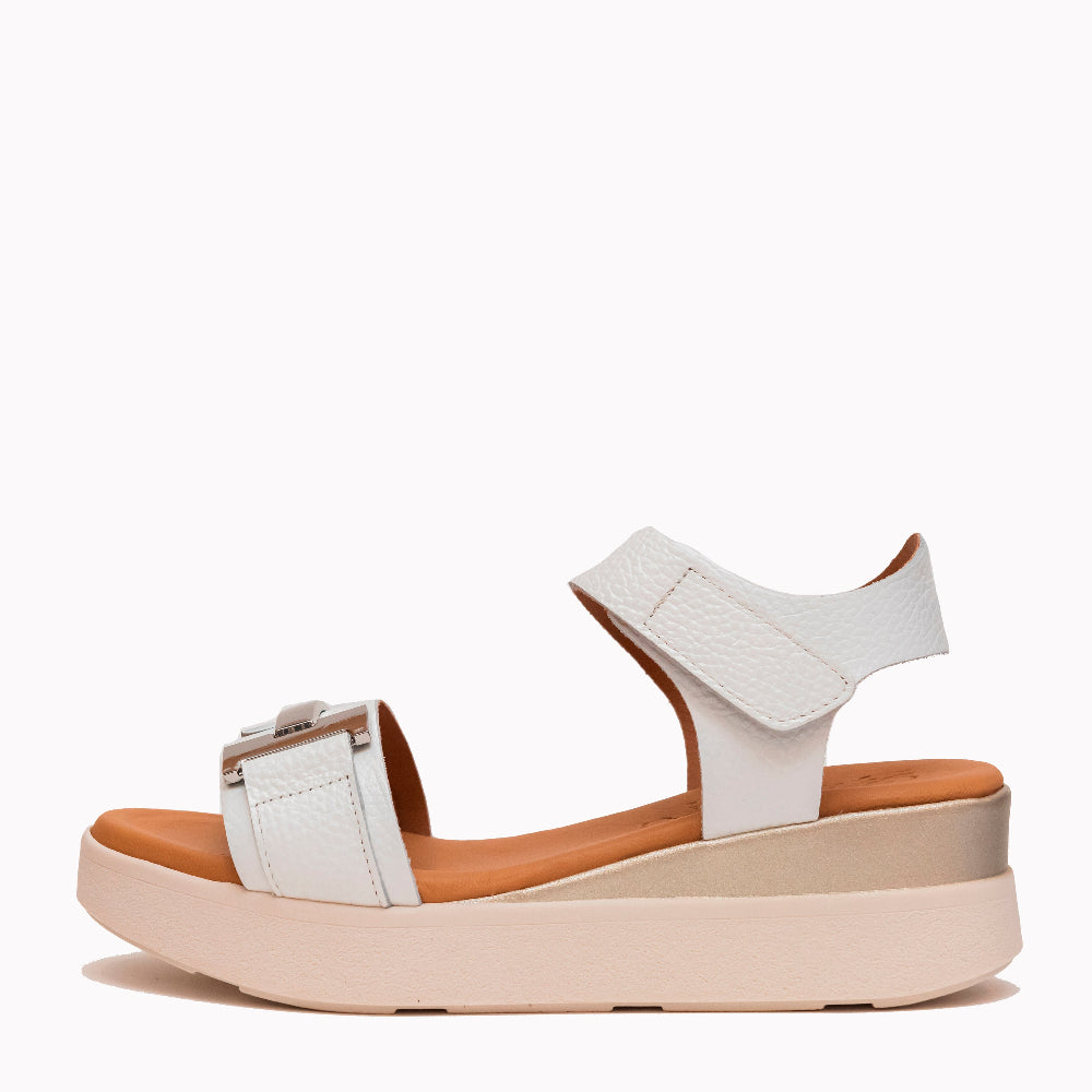 White sandal with a brown sole on a white background