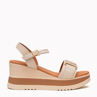 Beige wedge sandal with brown sole on a white background