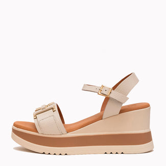 Beige wedge sandal with brown sole on a white background
