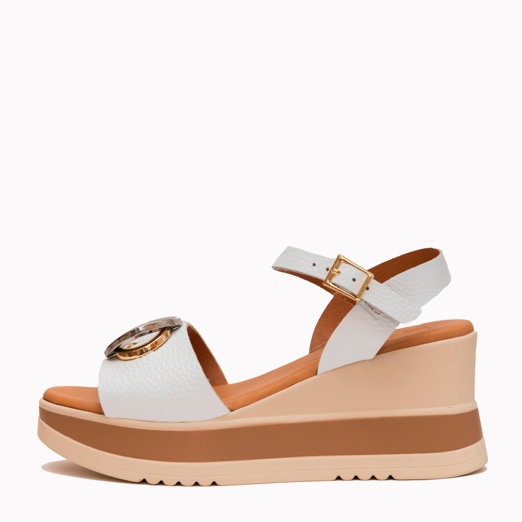 White wedge sandal with brown sole on a white background