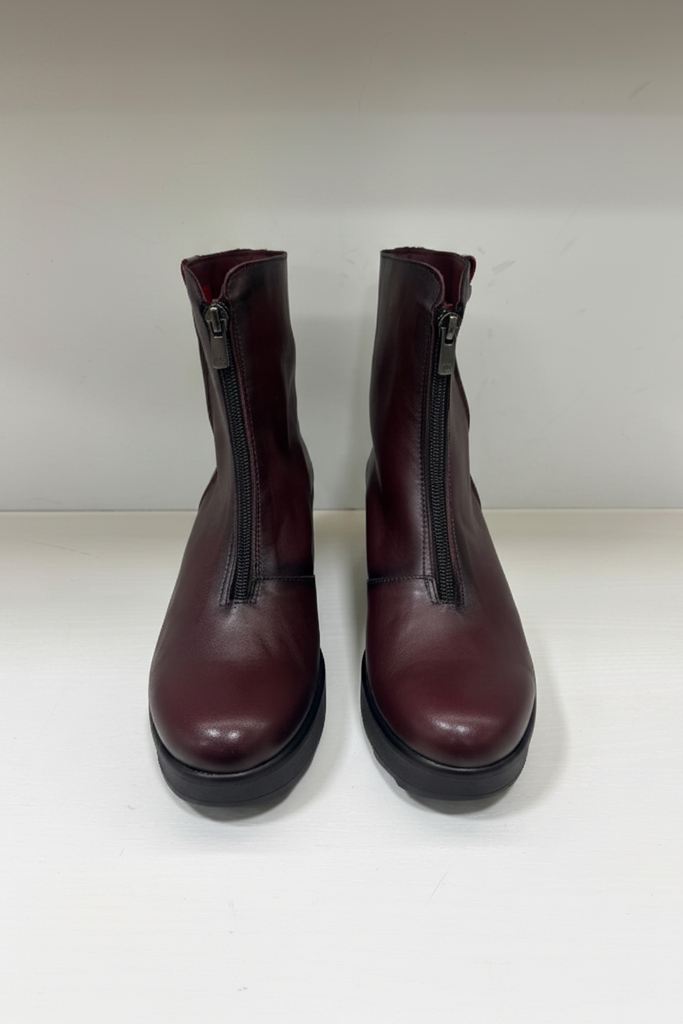 A pair of dark burgundy leather ankle boots with side zippers, shown from the front on a plain light background.