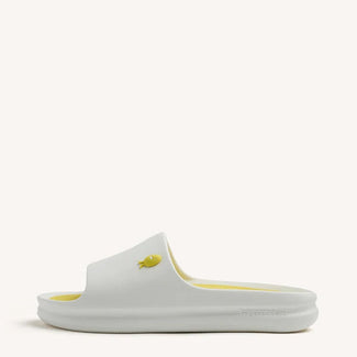 White slide sandal with yellow accents on a white background
