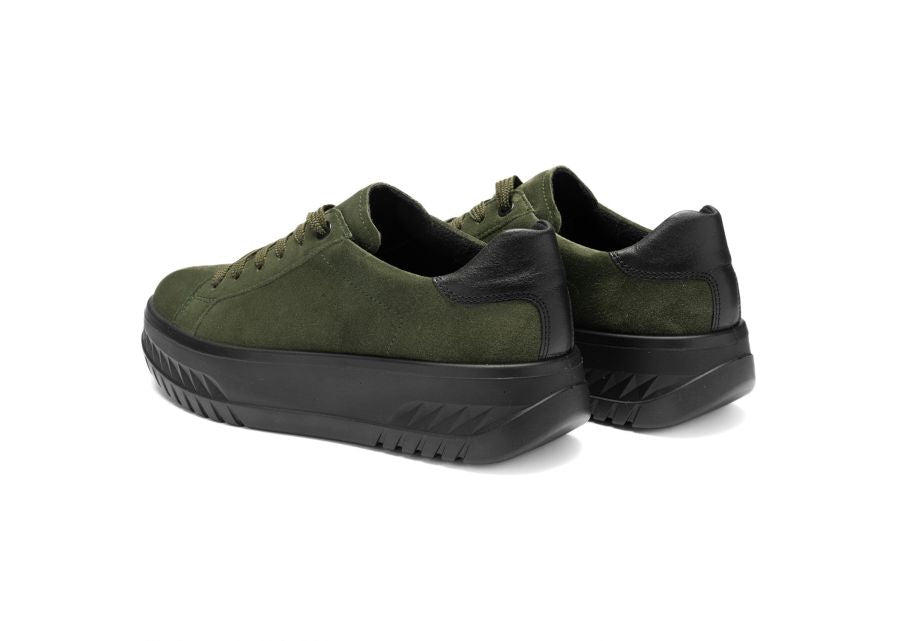 Green sneakers with black soles on a white background