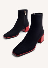 Load image into Gallery viewer, Black ankle boots with red soles on a white background
