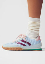 Load image into Gallery viewer, Light blue sneaker with pink accents worn with white socks on a neutral background
