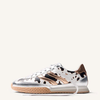 Sneaker with cow print pattern on a white background