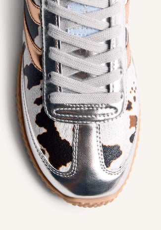 Pair of sneakers with cow print pattern on a white background
