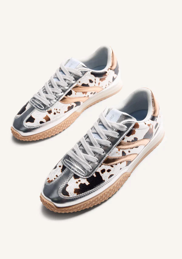 Pair of sneakers with cow print pattern on a white background