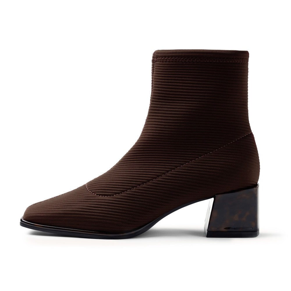 A dark brown ankle boot with a ribbed, textured fabric upper and a chunky block heel, shown in profile against a white background.