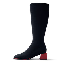 Load image into Gallery viewer, A single knee-high ribbed boot in black with a contrasting red block heel and red outsole edge, shown in profile against a white background.
