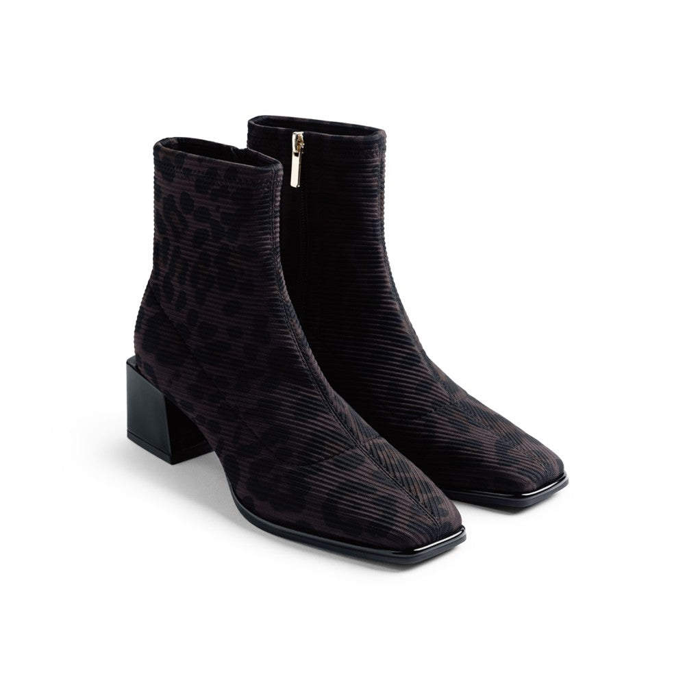 A pair of black textured ankle boots with a subtle snakeskin pattern, square toes, and low block heels, shown on a clean white background.