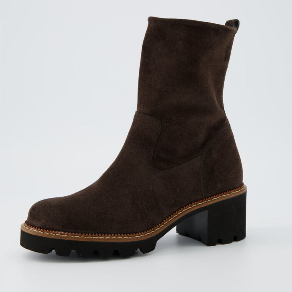 Brown suede boot on a light gray background