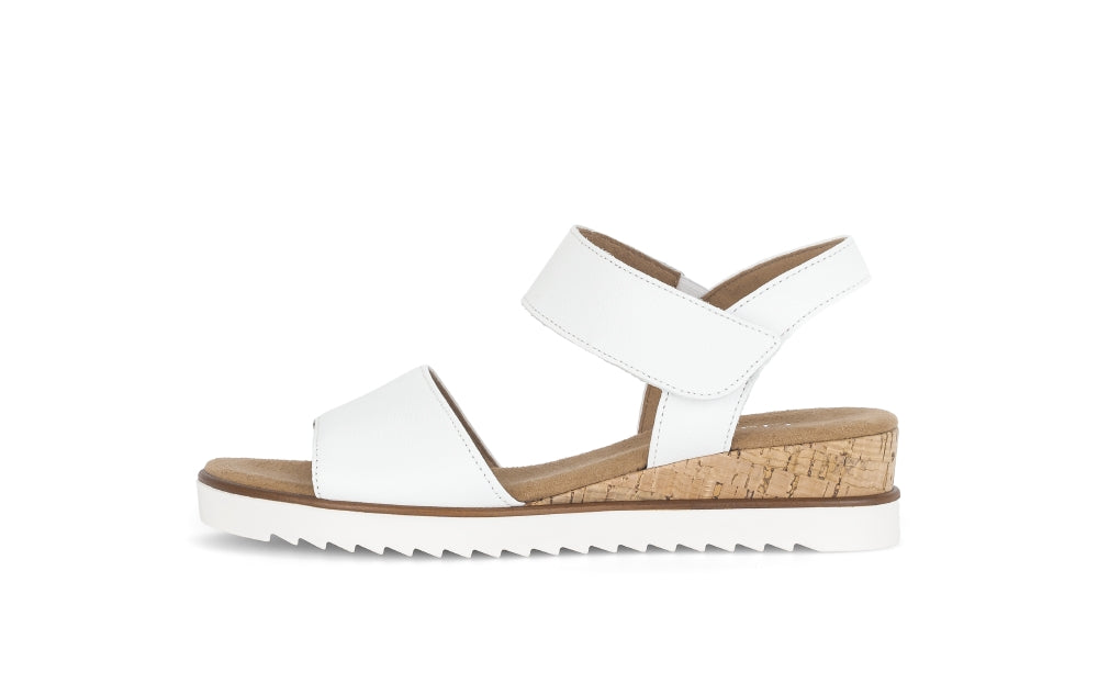White sandal with cork wedge sole on a white background