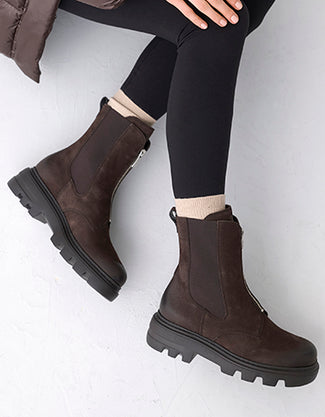 Brown leather boot with a thick sole on a light gray background