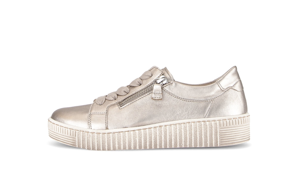 gold sneaker with a platform sole on a white background