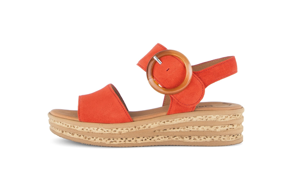 red sandal with wooden buckle on a white background