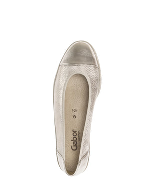 Gold wedge shoe on a white background