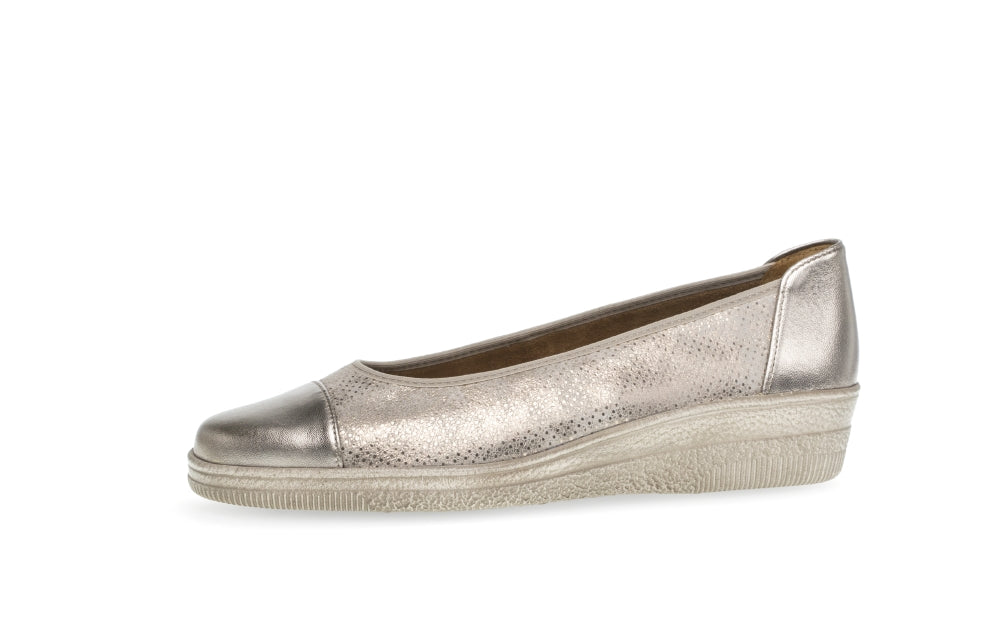 Gold wedge shoe on a white background