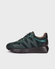 Load image into Gallery viewer, A dark green New Balance sneaker with a textured leather upper, metallic green accents, black laces, and a chunky black sole, shown from a side profile on a light gray background.
