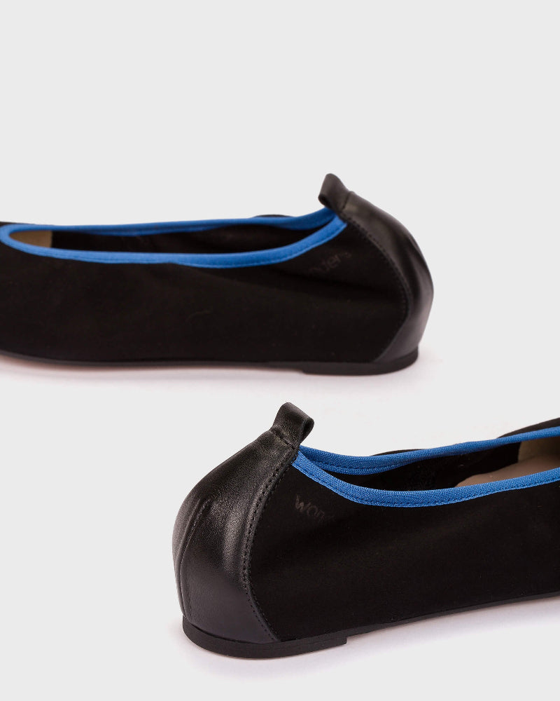Black ballet flats with blue interior on a white background