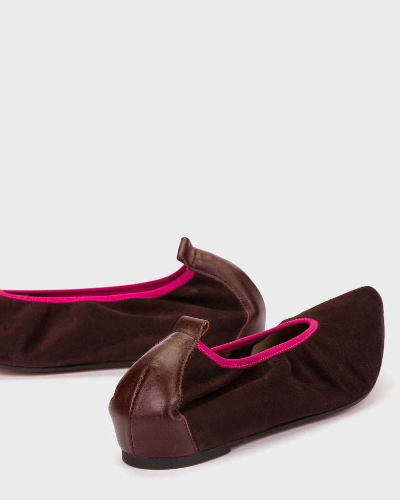Brown slippers with pink interior lining on a white background